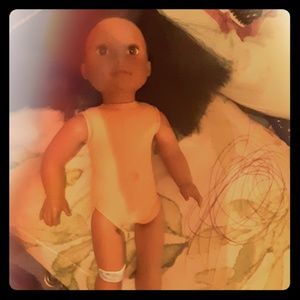 A baby doll with clothes and a mini bag